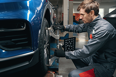 Technicians aligning a car's wheels
