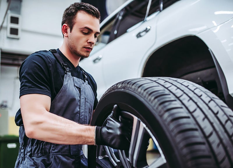 A technician measuring tire tread depth